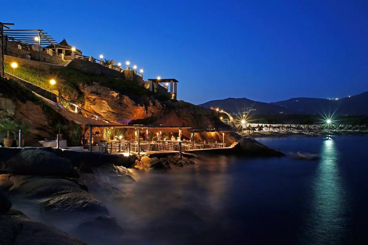 Stunning seaside view of Spilia Mykonos restaurant, nestled by the rocks with crystal-clear waters below